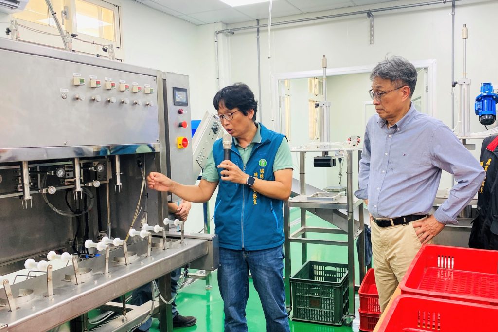 瑞穗鄉農會總幹事黃盛皇（左）向農業部長陳駿季示範文旦削皮機的操作。（圖片提供／農糧署）